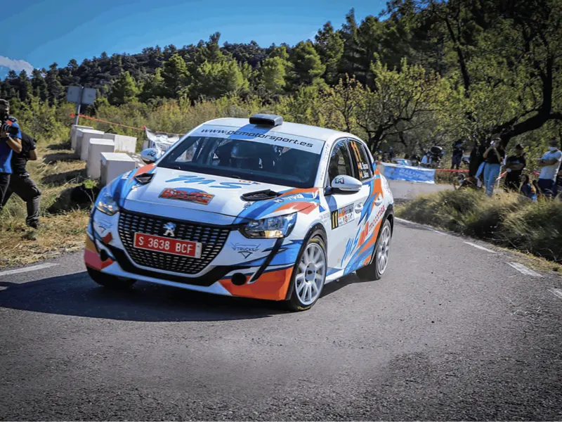 Coche de rally rotulado en un tramo de asfalto
