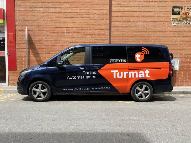 Furgoneta negra rotulada para una empresa de servicios